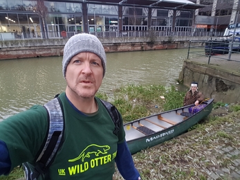 The Canoe River Cleaner in front of his canoe. The canal is in the background 