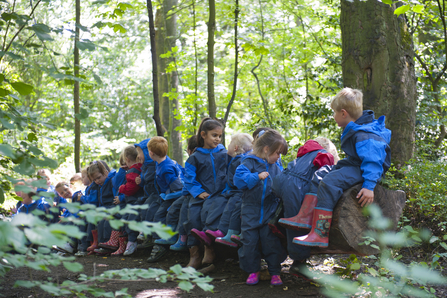 children in blue overalls in woods