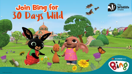 Animated characters Bing, Flop and Sula stand together in a colourful park filled with flowers, trees and wildlife, with ducks flying overhead and butterflies nearby; text reads “Join Bing for 30 Days Wild”